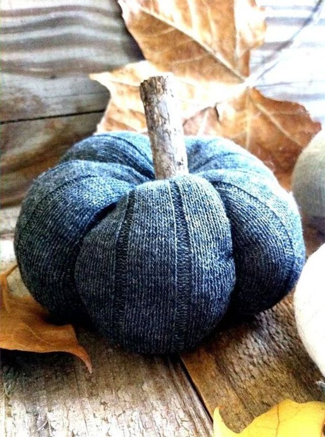 Una calabaza azul junto a las hojas del otoño