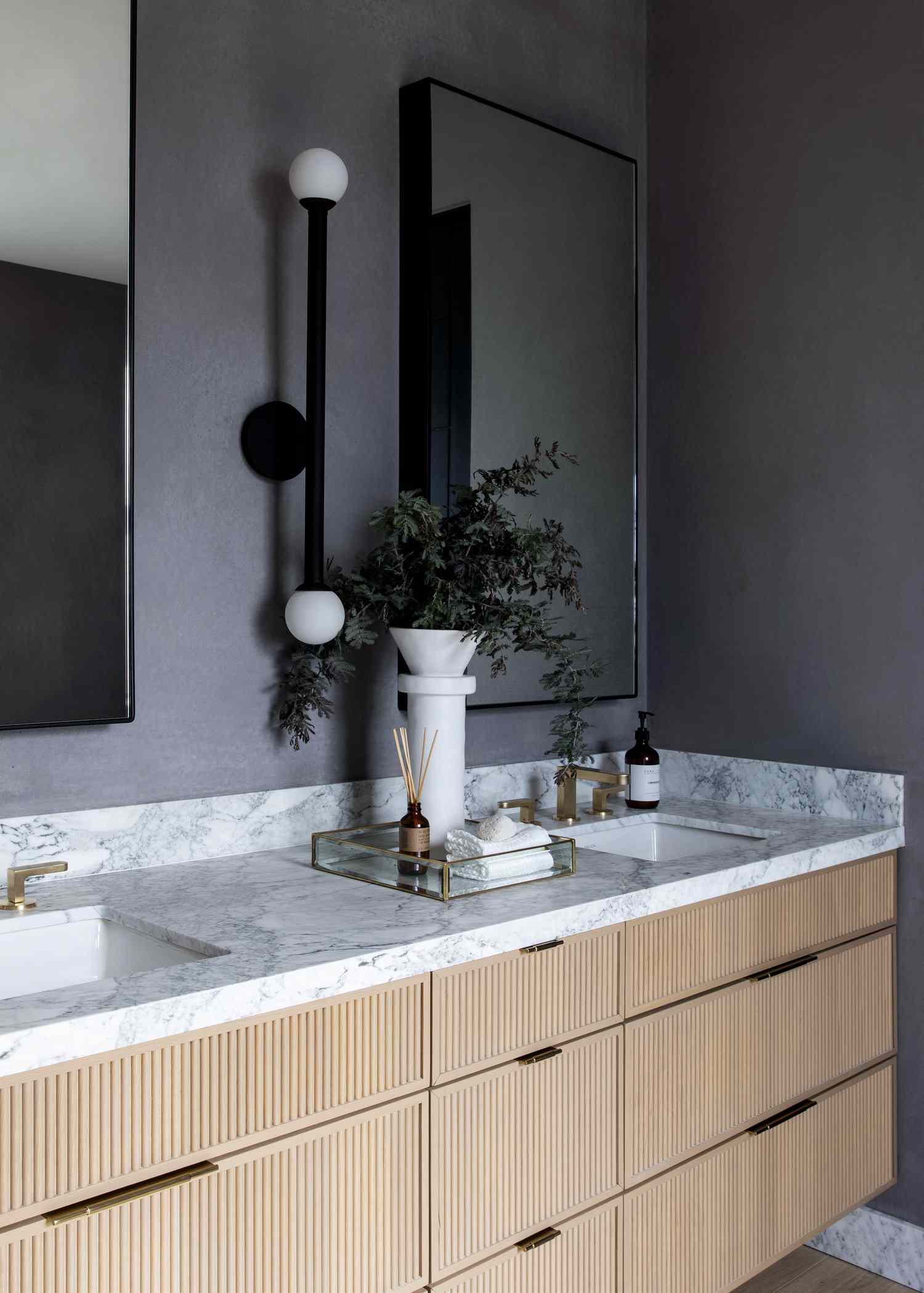 salle de bain avec murs gris et lavabo en marbre blanc vanité