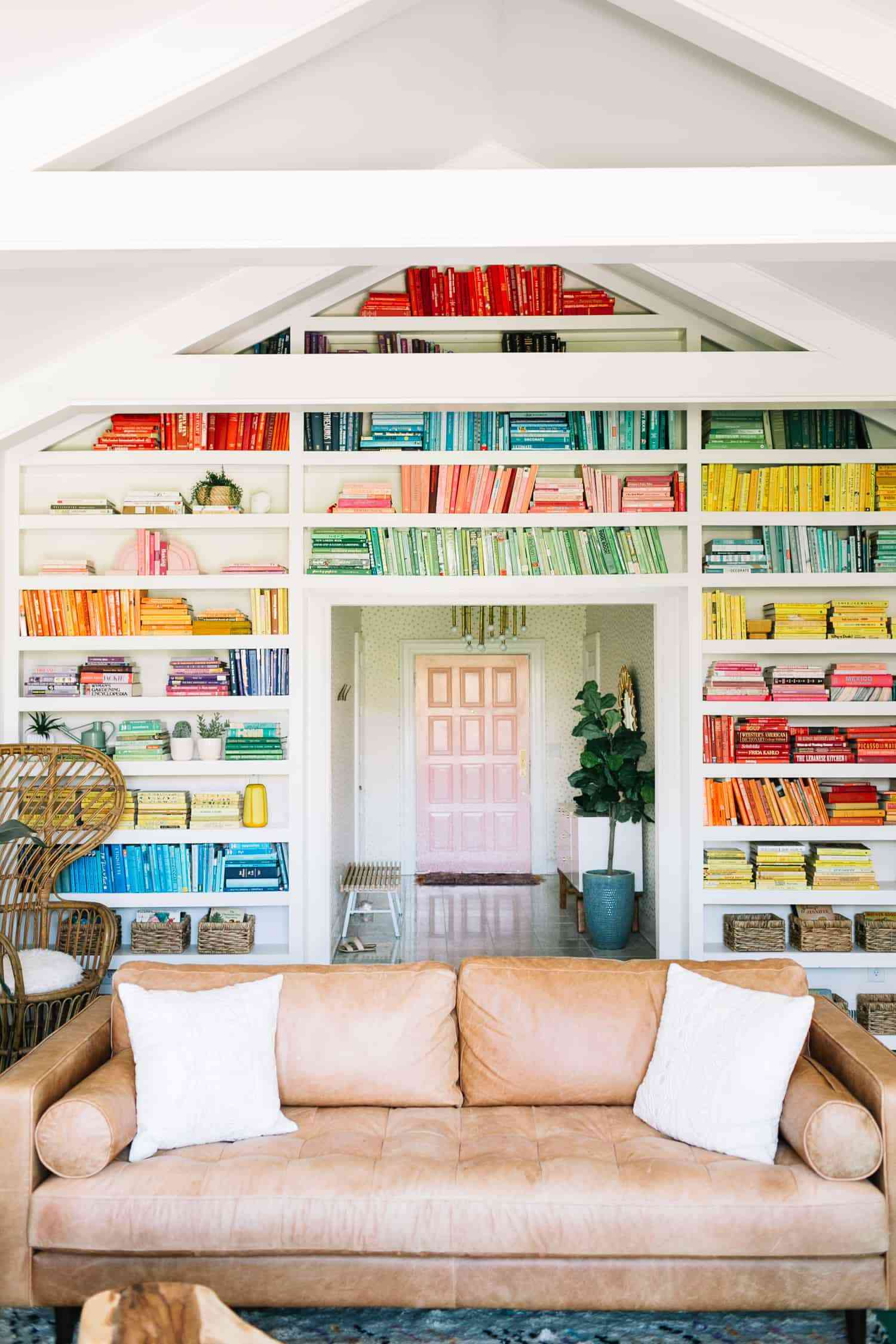Nach Farben geordnete Bücher in einem riesigen Wandbuchregal