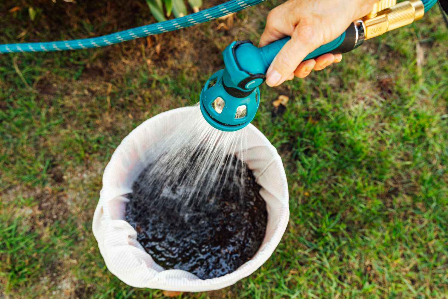 Einen Eimer Gülle mit Wasser füllen