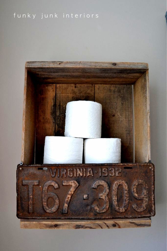 Ein Holzregal mit einem alten Nummernschild und Toilettenpapier