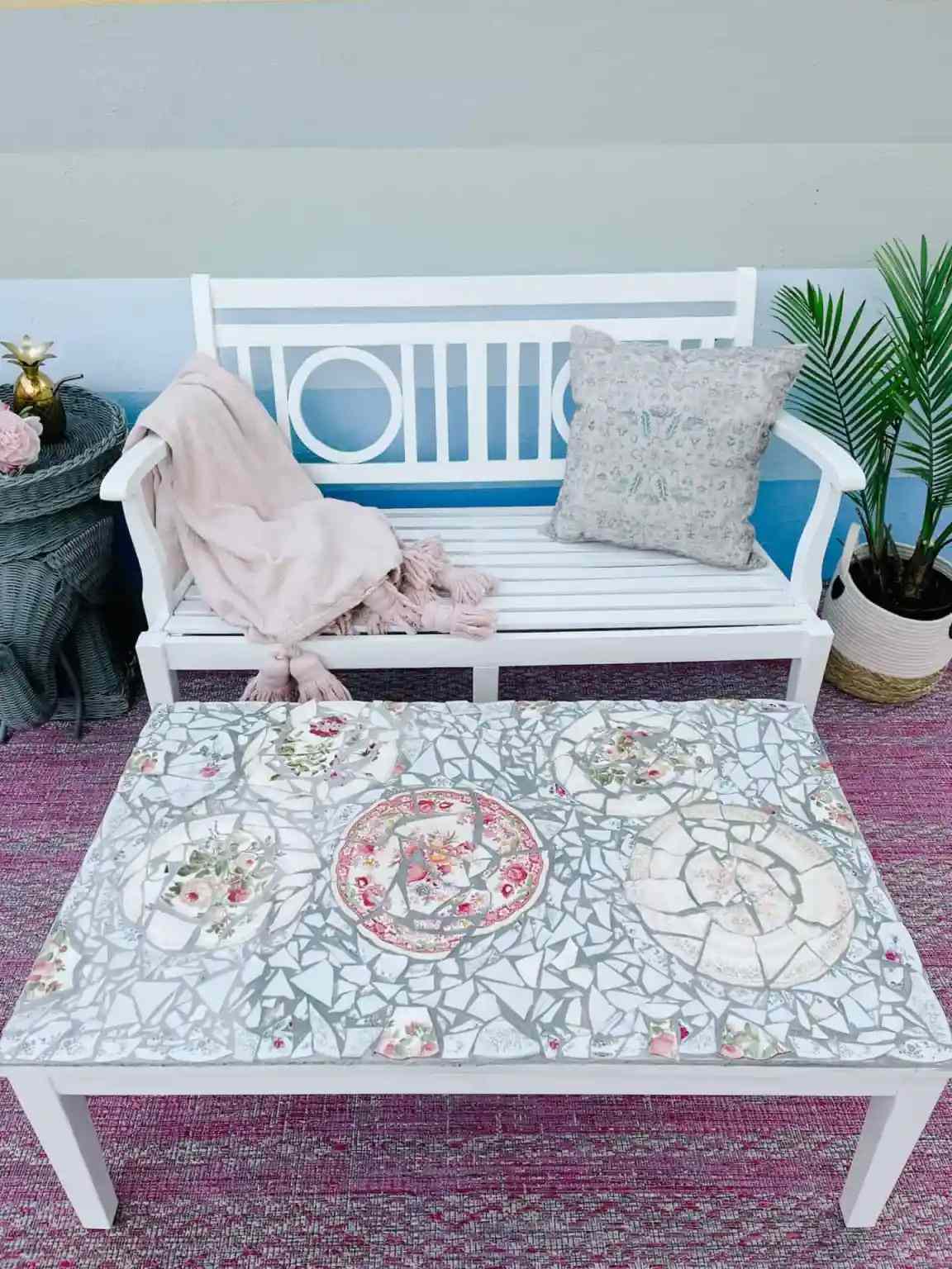 Une table basse extérieure avec mosaïque de vaisselle cassée