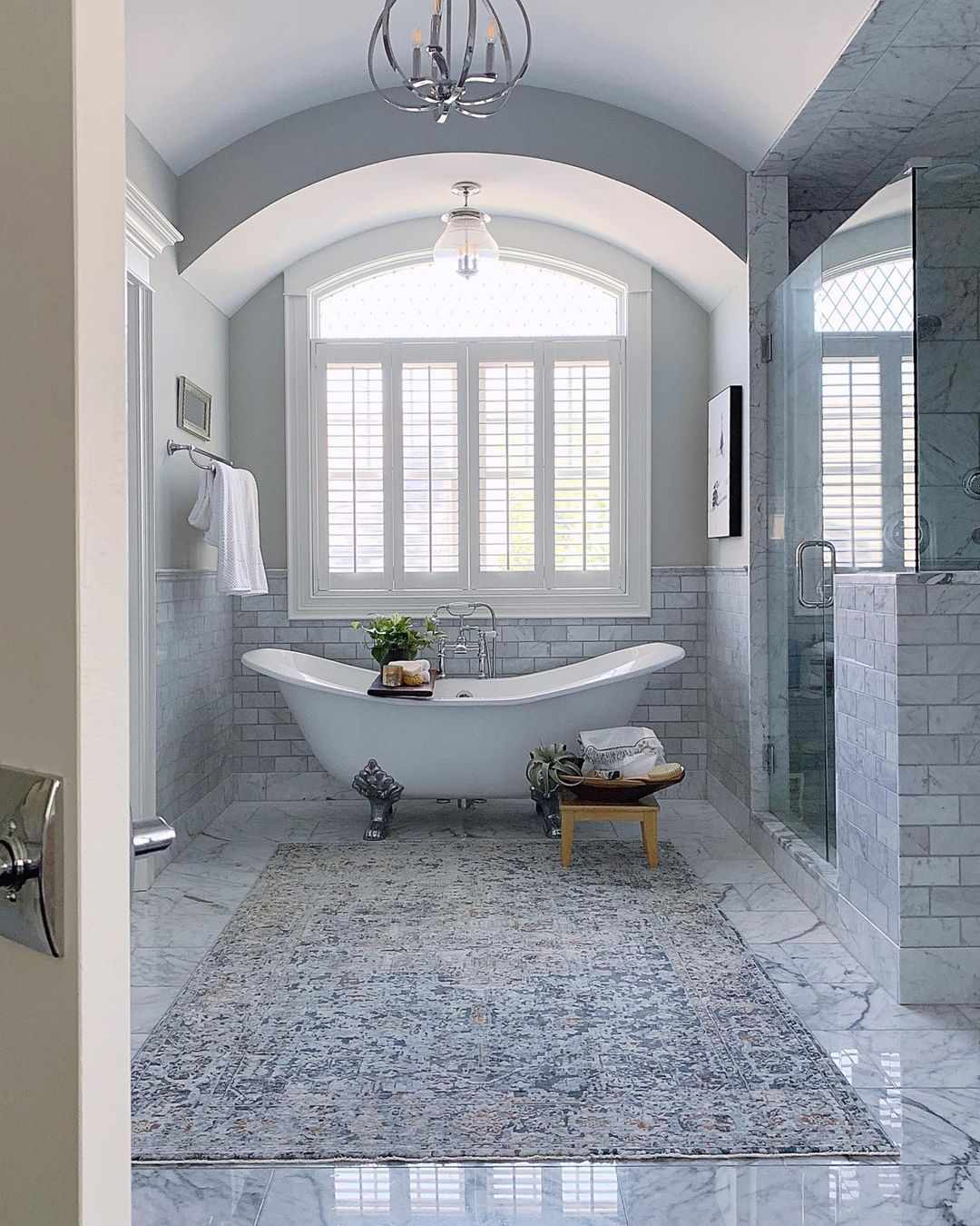 Um grande tapete de área em um banheiro luxuoso com uma banheira independente