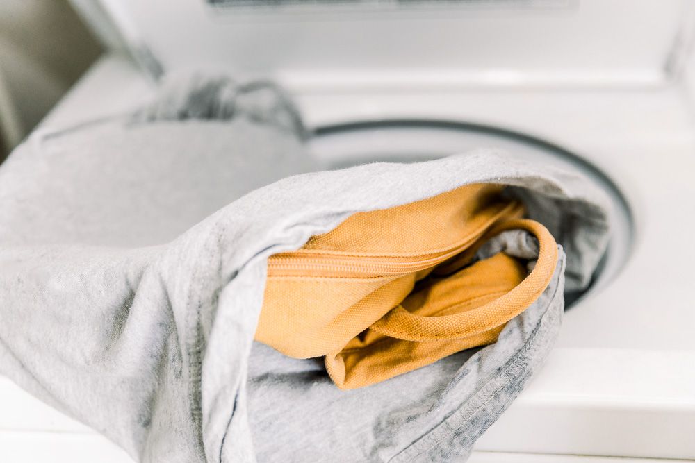 A backpack in a pillowcase on a washer