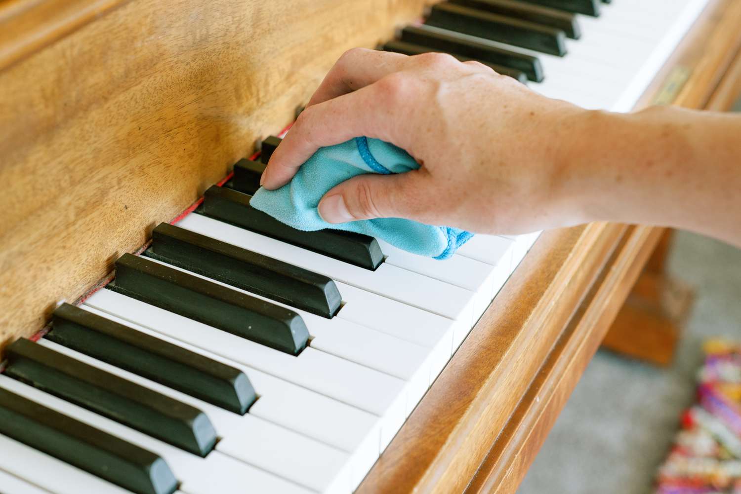 Limpieza de teclas de piano de marfil con un paño de microfibra