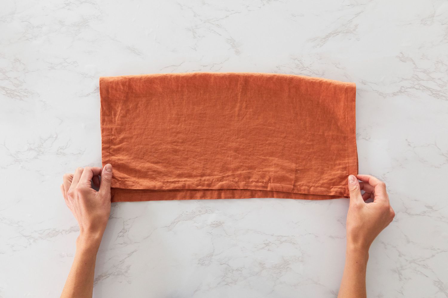 Orange cloth napkin folded in half horizontally