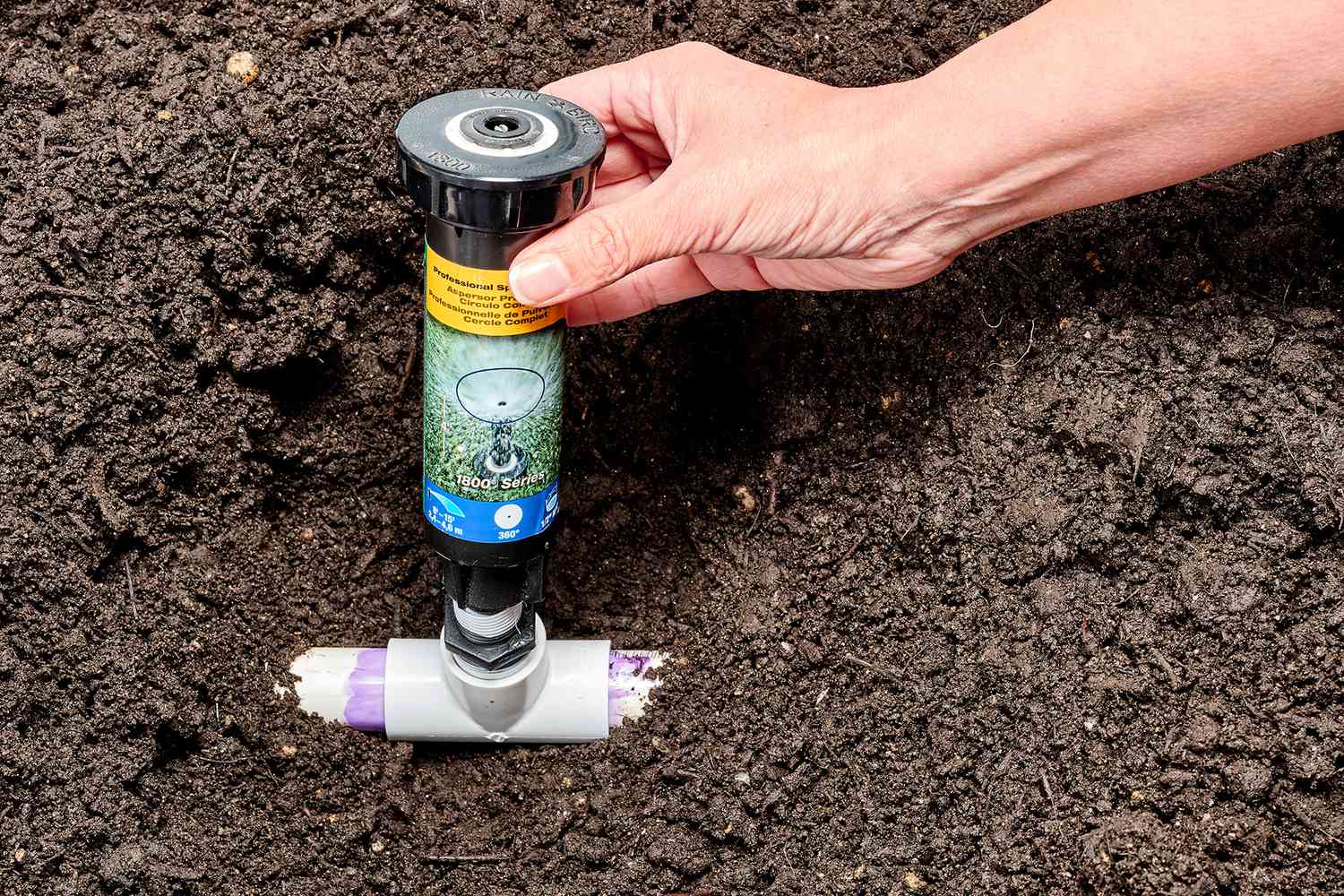 PVC-Sattel-T-Stück verbunden mit Rasensprenger im Boden