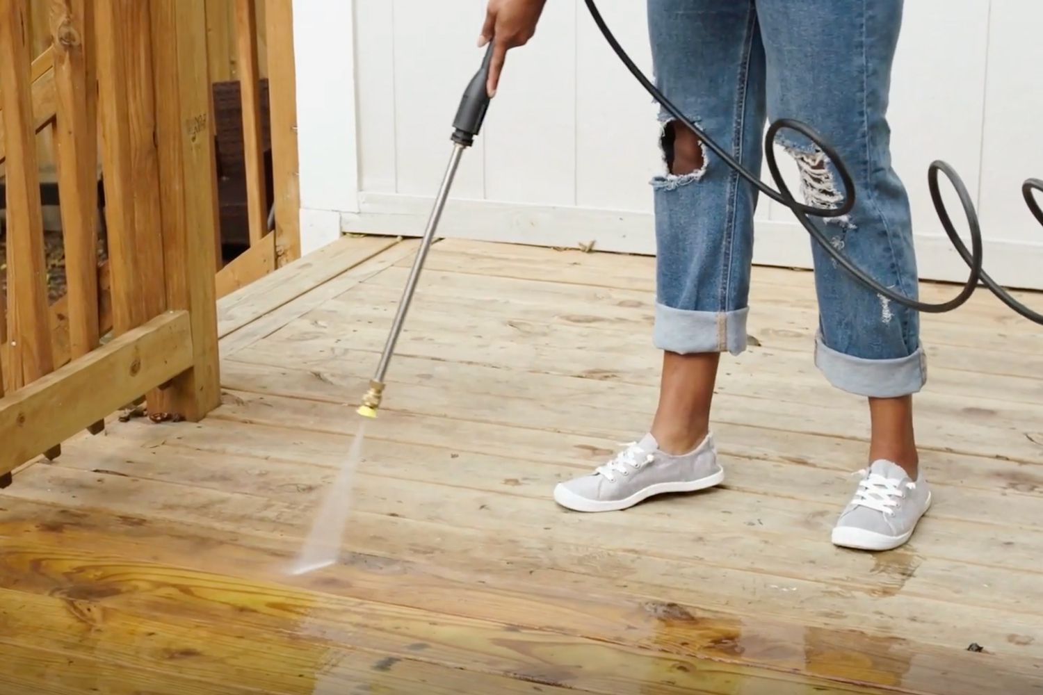 person power washing a wood deck