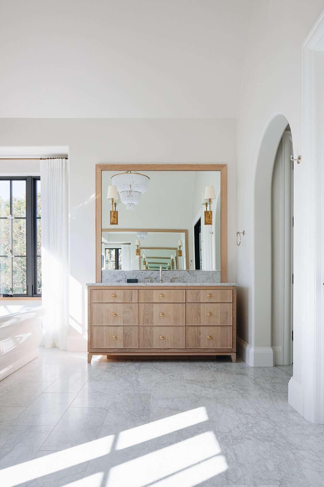grande salle de bain avec vanité en bois et sol en marbre