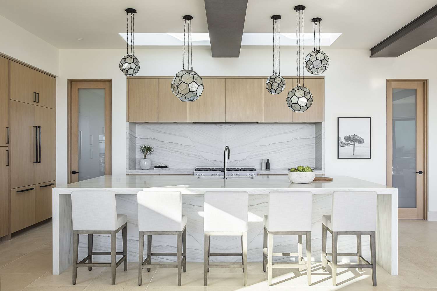 modern white kitchen with geometric statement light pendants