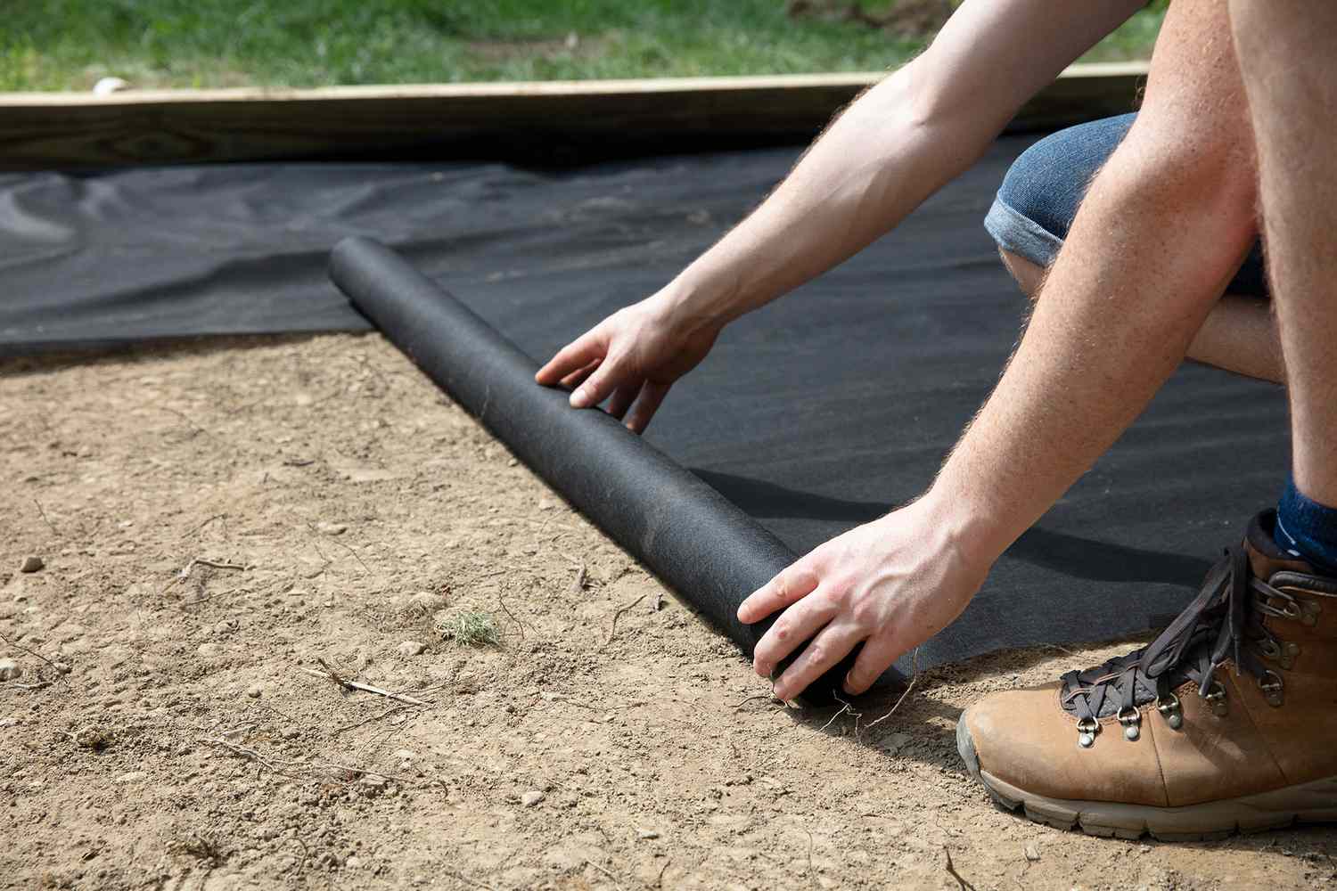 Landschaftsgewebe über Erde für Erbsenkies-Terrasse verlegt