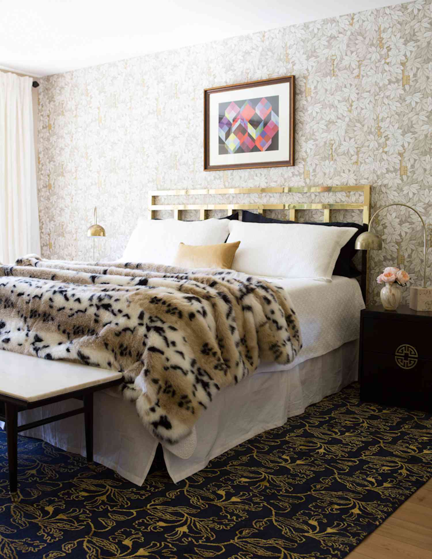 modern bedroom with leopard print fur blanket, golden headboard, tan and beige accents, glam