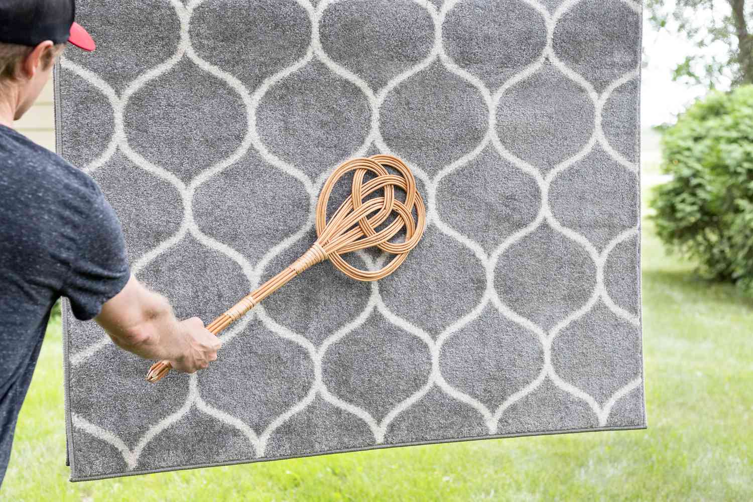 Person using a carpet beater