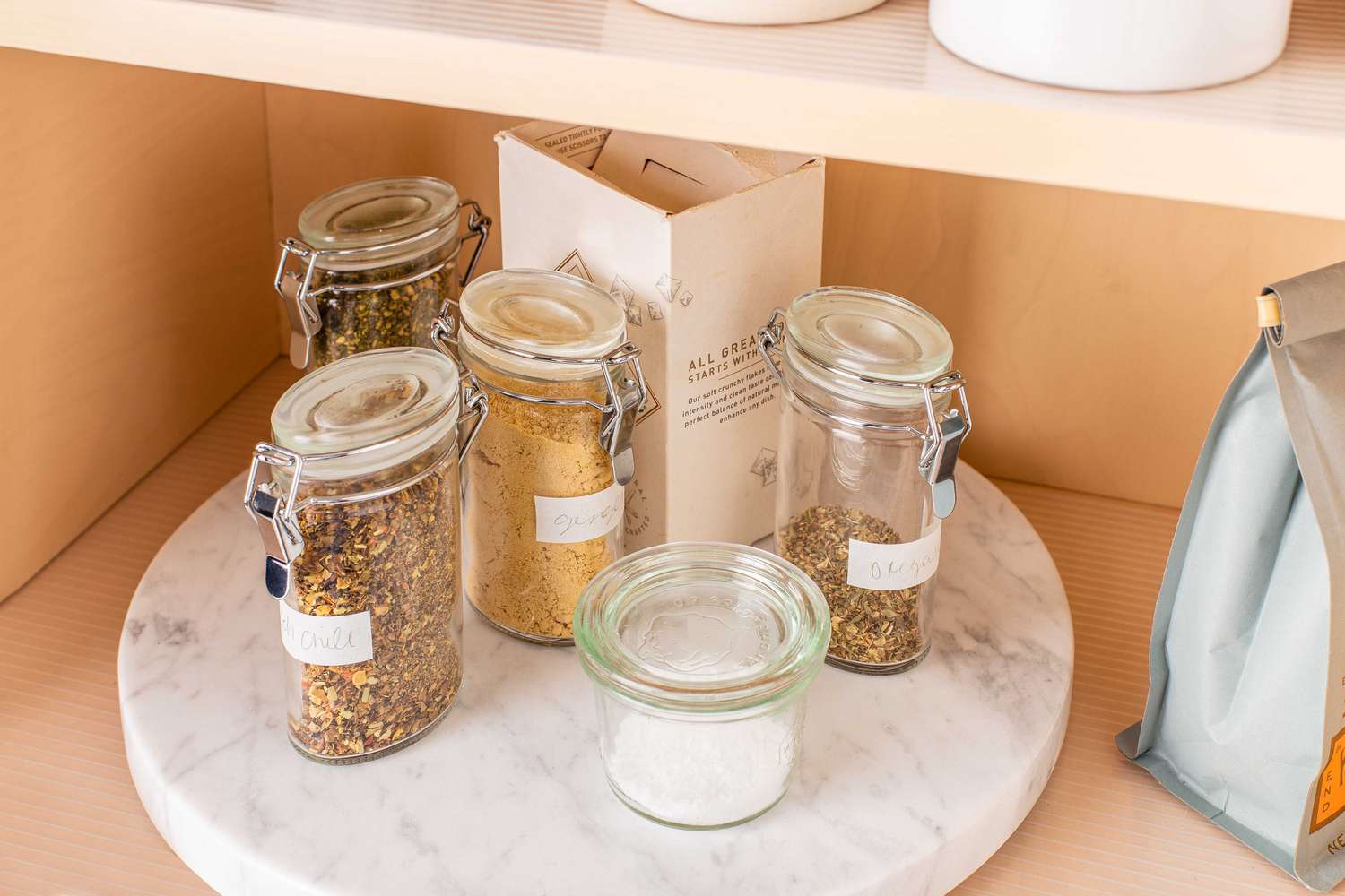 Lazy Susan circulaire et marbre tenant des récipients à épices en verre dans une étagère de cuisine