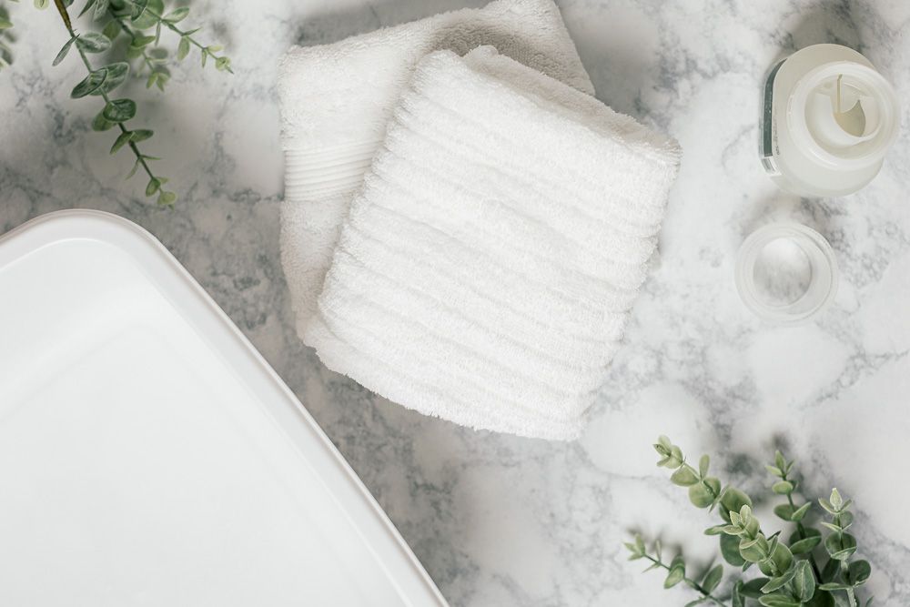 Weiße Behälter und Handtücher zum Waschen von Häkeldecken