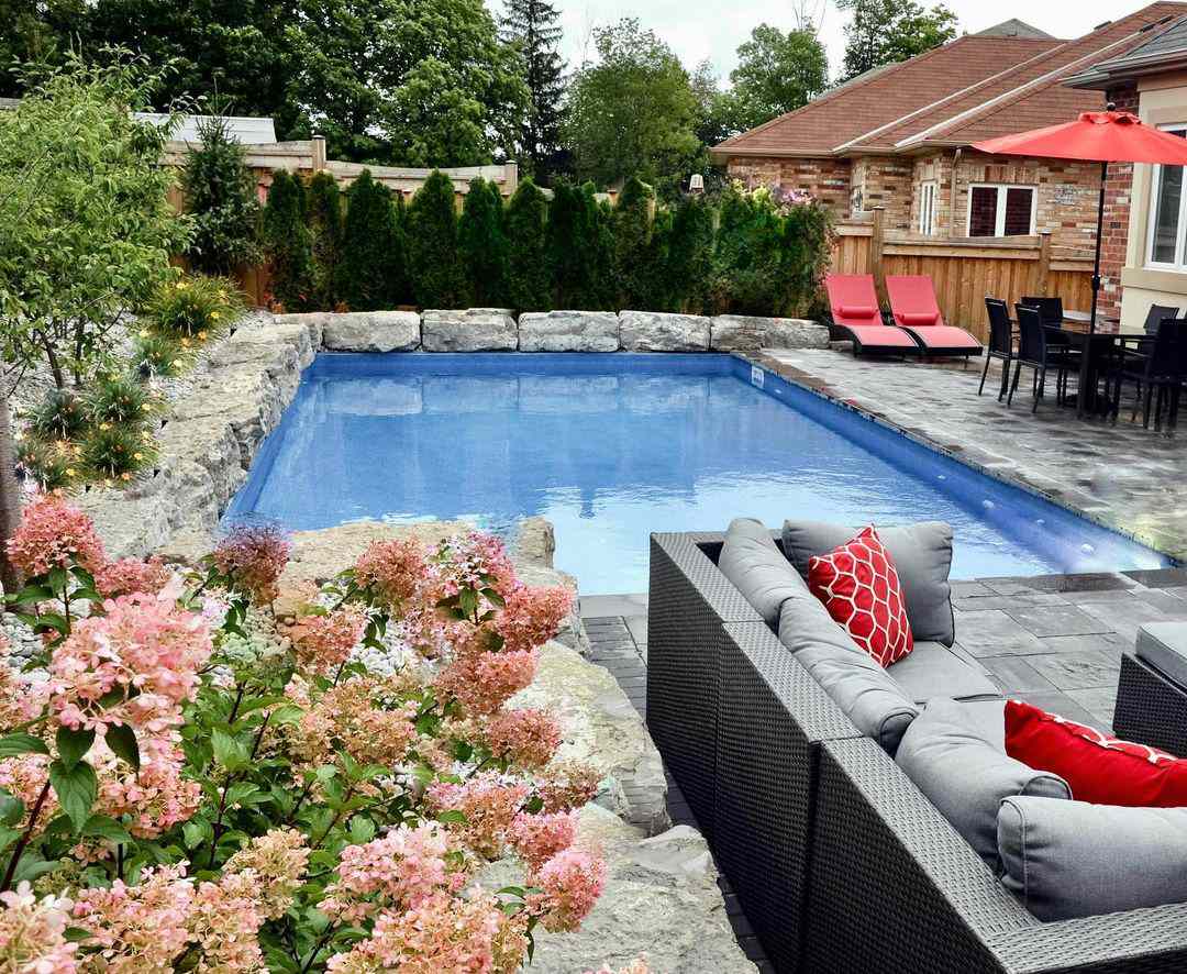 Una piscina en el patio trasero con un borde de cantos rodados