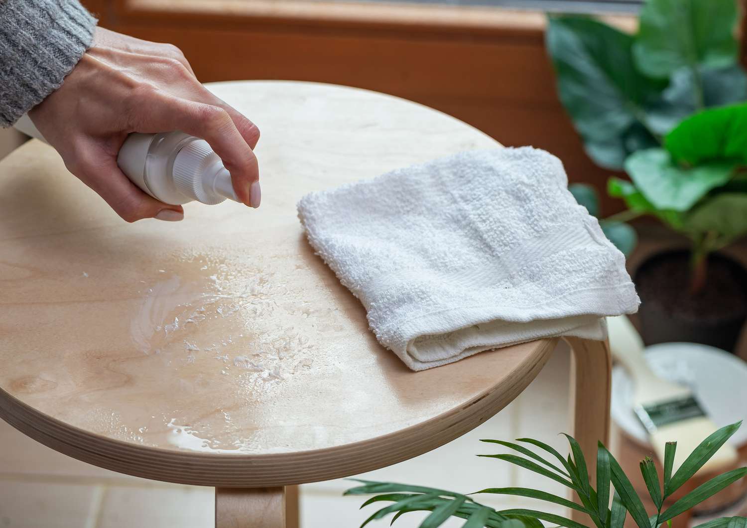 spraying furniture polish onto a glue stain