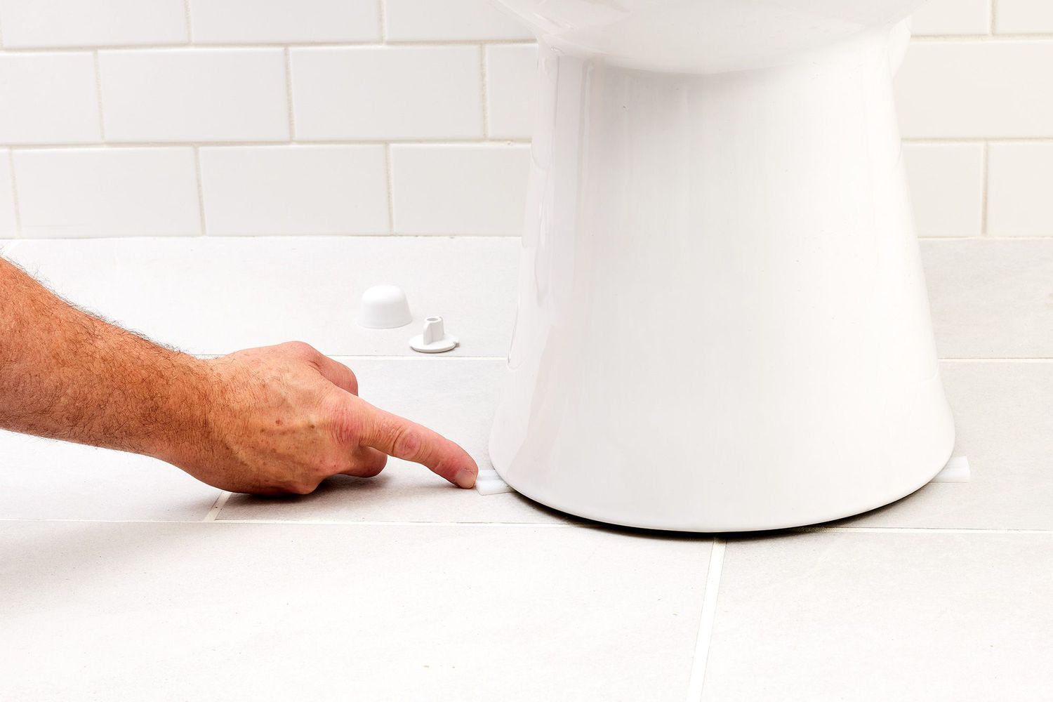 Toilet shims placed under toilet for leveling