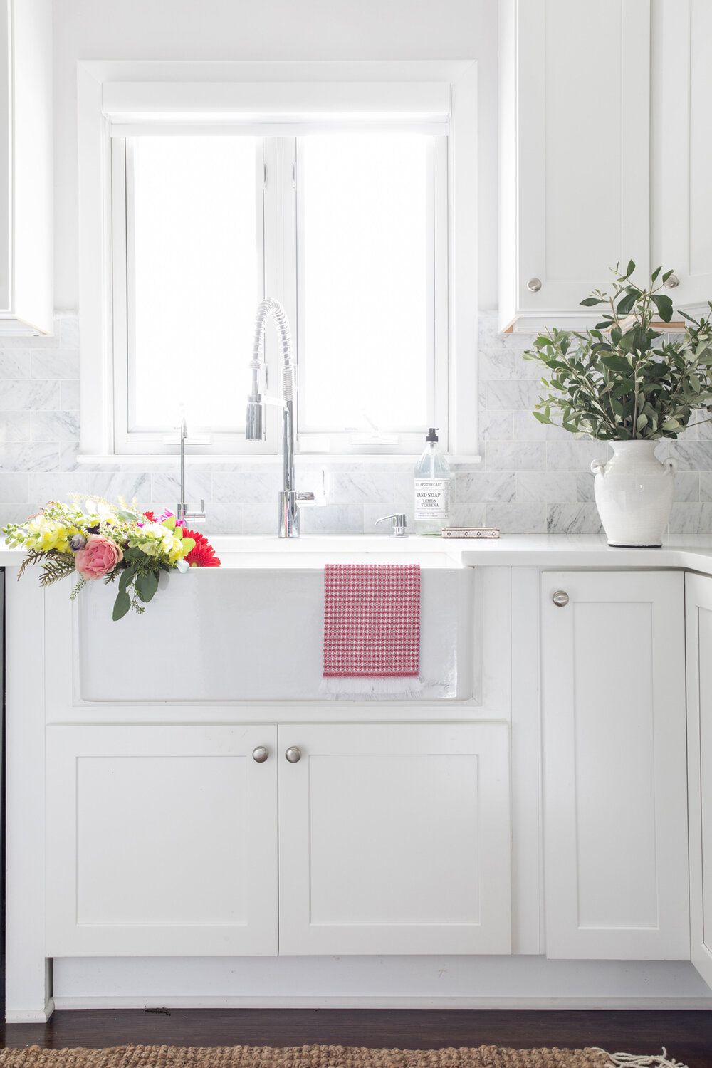 Eine weiße Küche mit Wasserhahn und Spülbecken