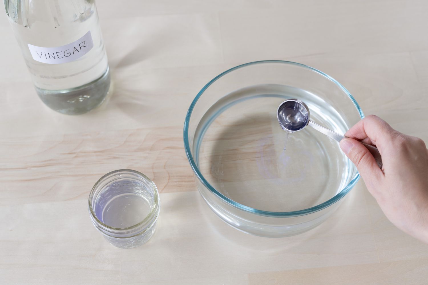 Destillierter weißer Essig in eine Glasschüssel mit Wasser gegossen als Reinigungslösung