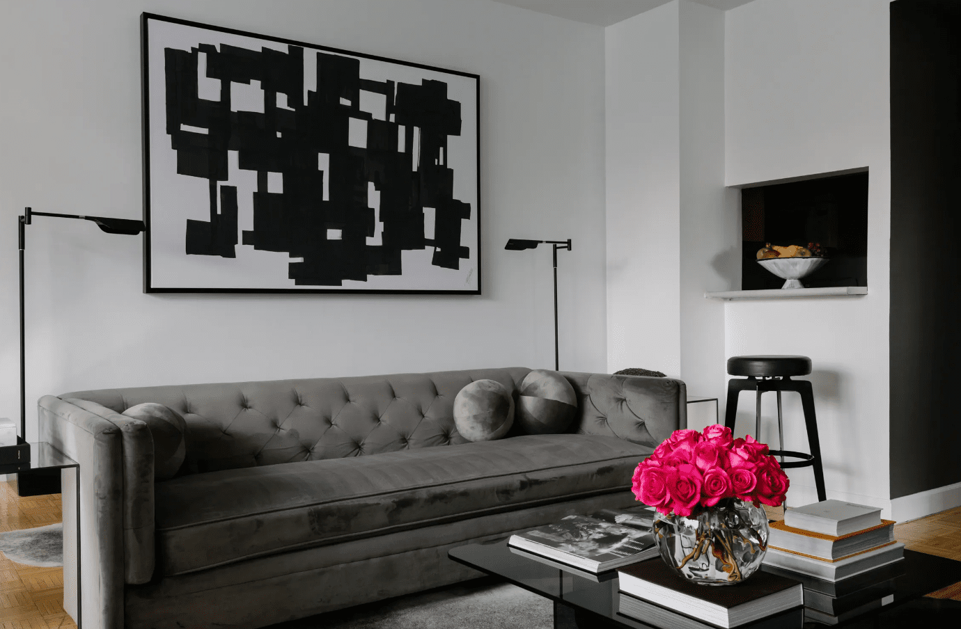 salon gris, noir et blanc avec des roses lumineuses dans un vase