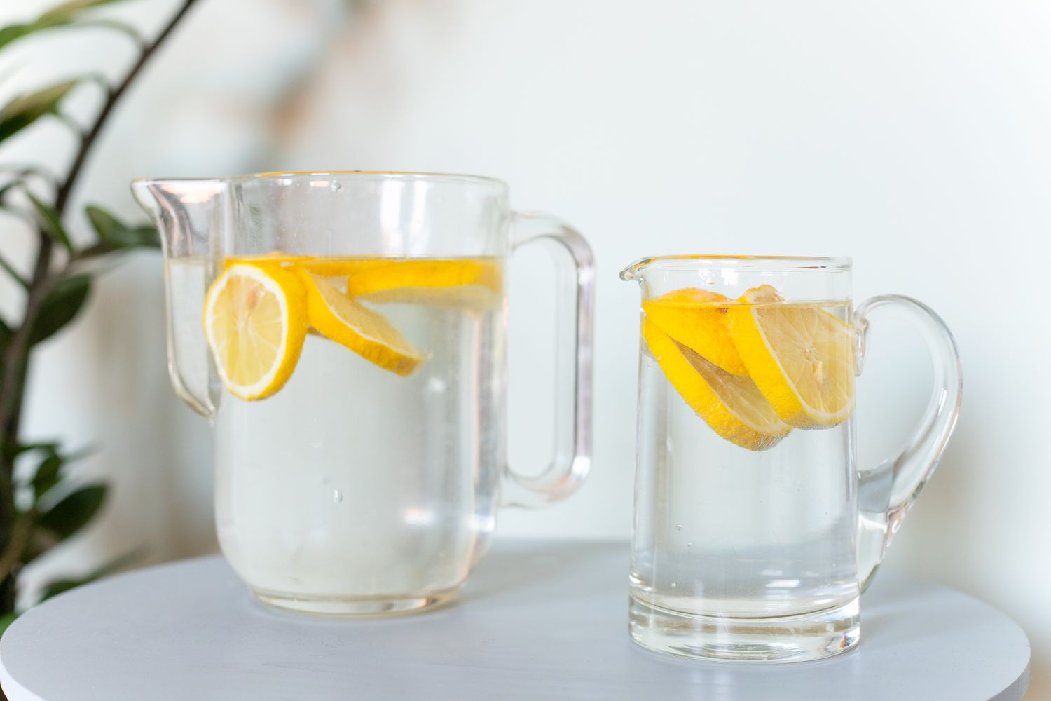 Limones en rodajas flotando en jarras de cristal con agua