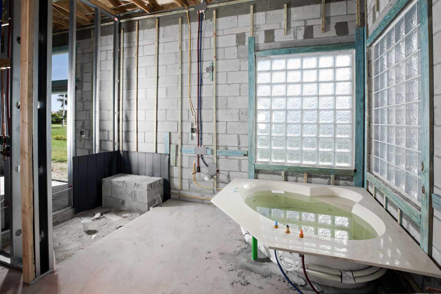 Banheiro com jacuzzi sendo construído com parede de blocos de vidro