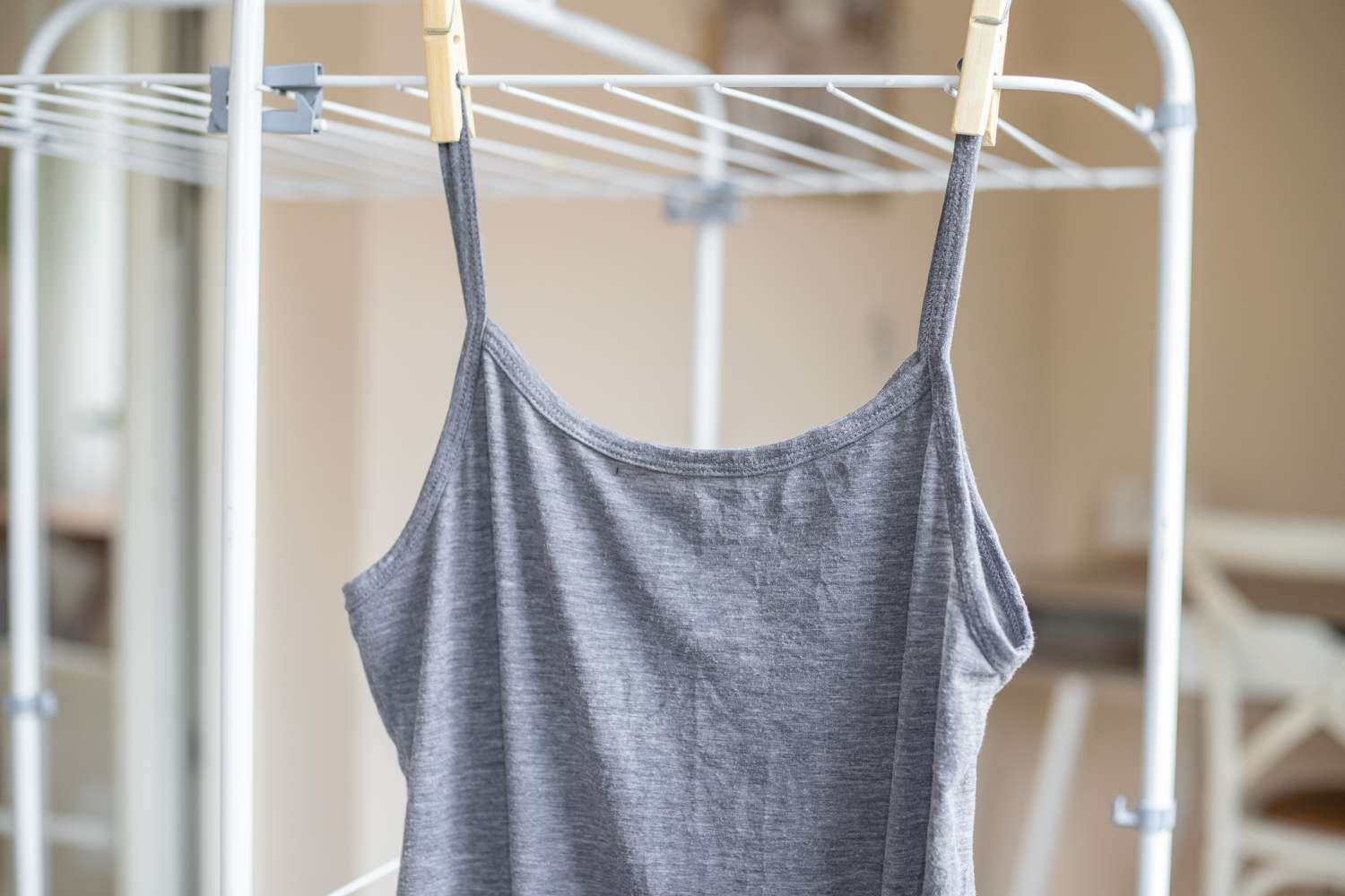 Graues Tanktop zum Lufttrocknen auf dem Trockengestell aufgehängt