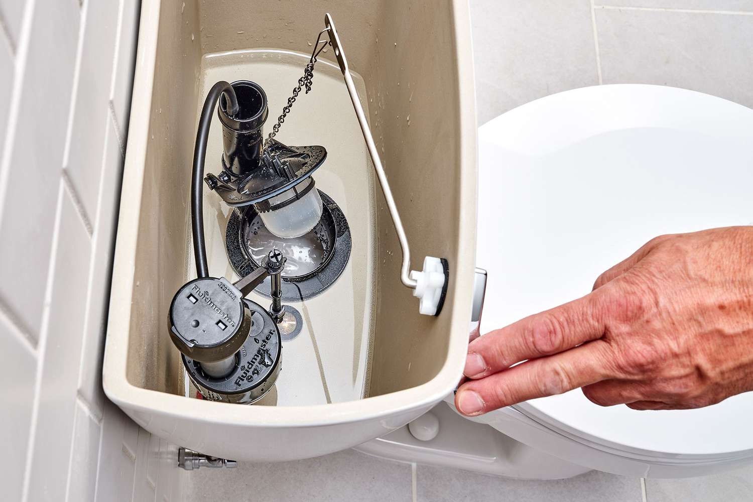 Toilettengriff nach unten gedrückt, um die Wasserspülung zu überprüfen