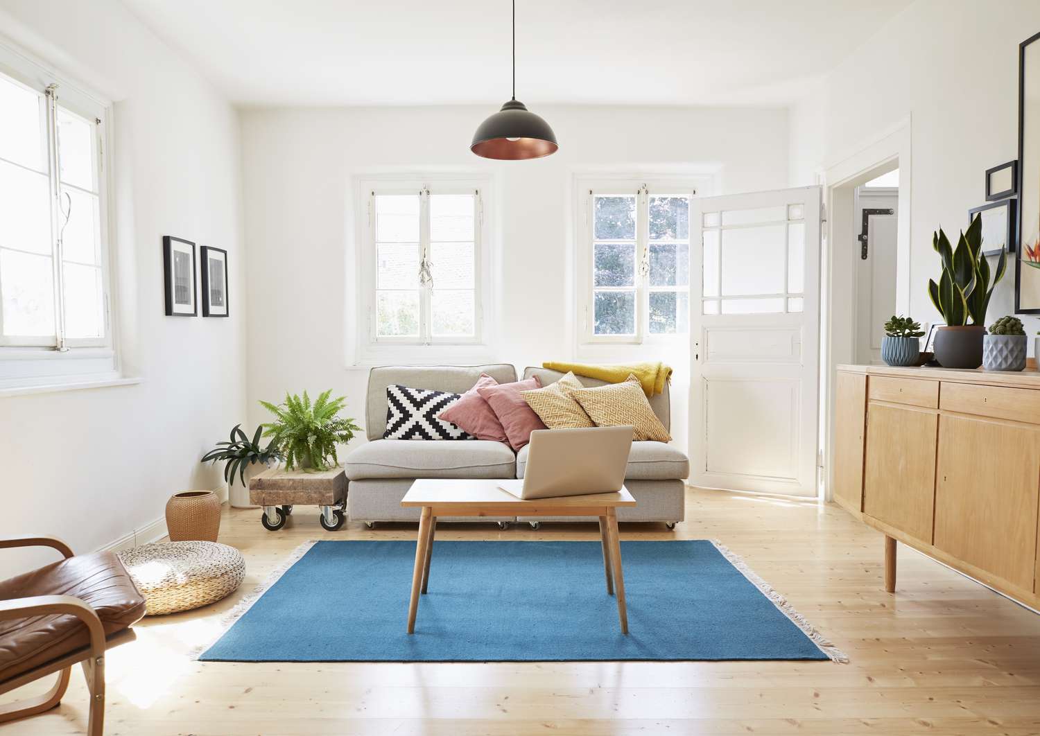 Ordenador portátil sobre mesa de centro en un moderno salón de una antigua casa de campo