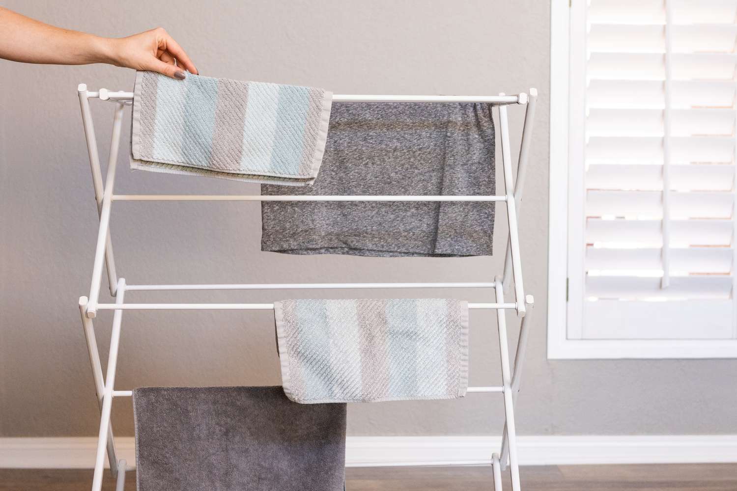 Falten von Handtüchern und Kleidungsstücken über einem Trockengestell