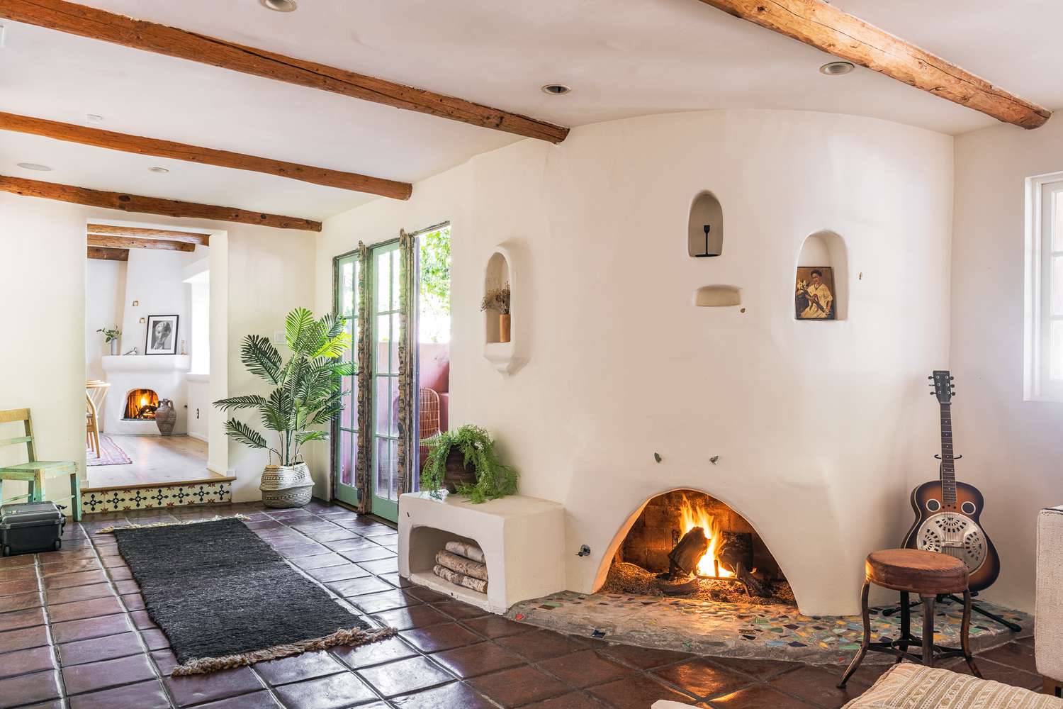 Wohnzimmer eines Hauses im spanischen Stil mit Kamin und Holzbalken an der Decke