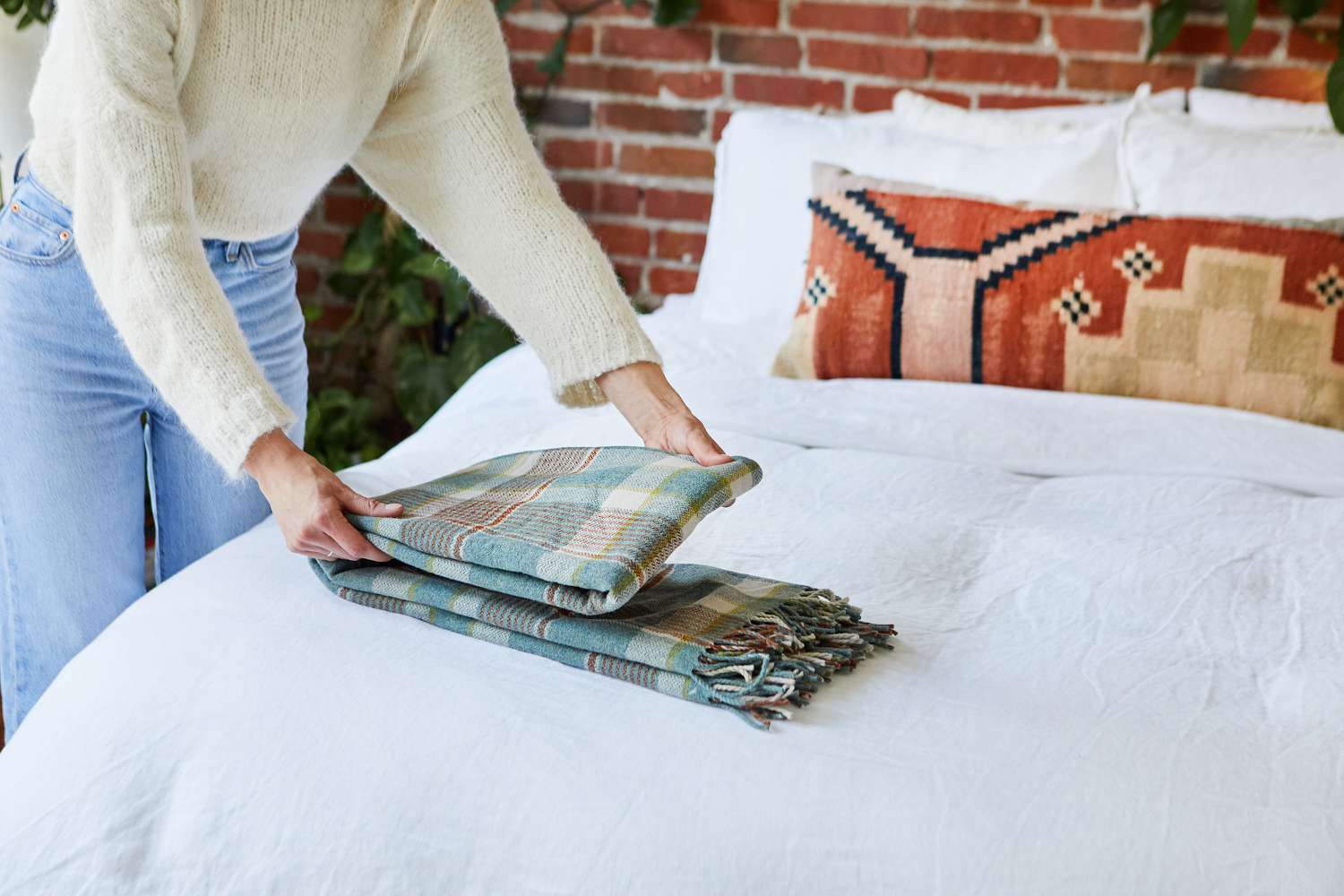 Cobertor com estampa fina dobrado em terços em cima da cama
