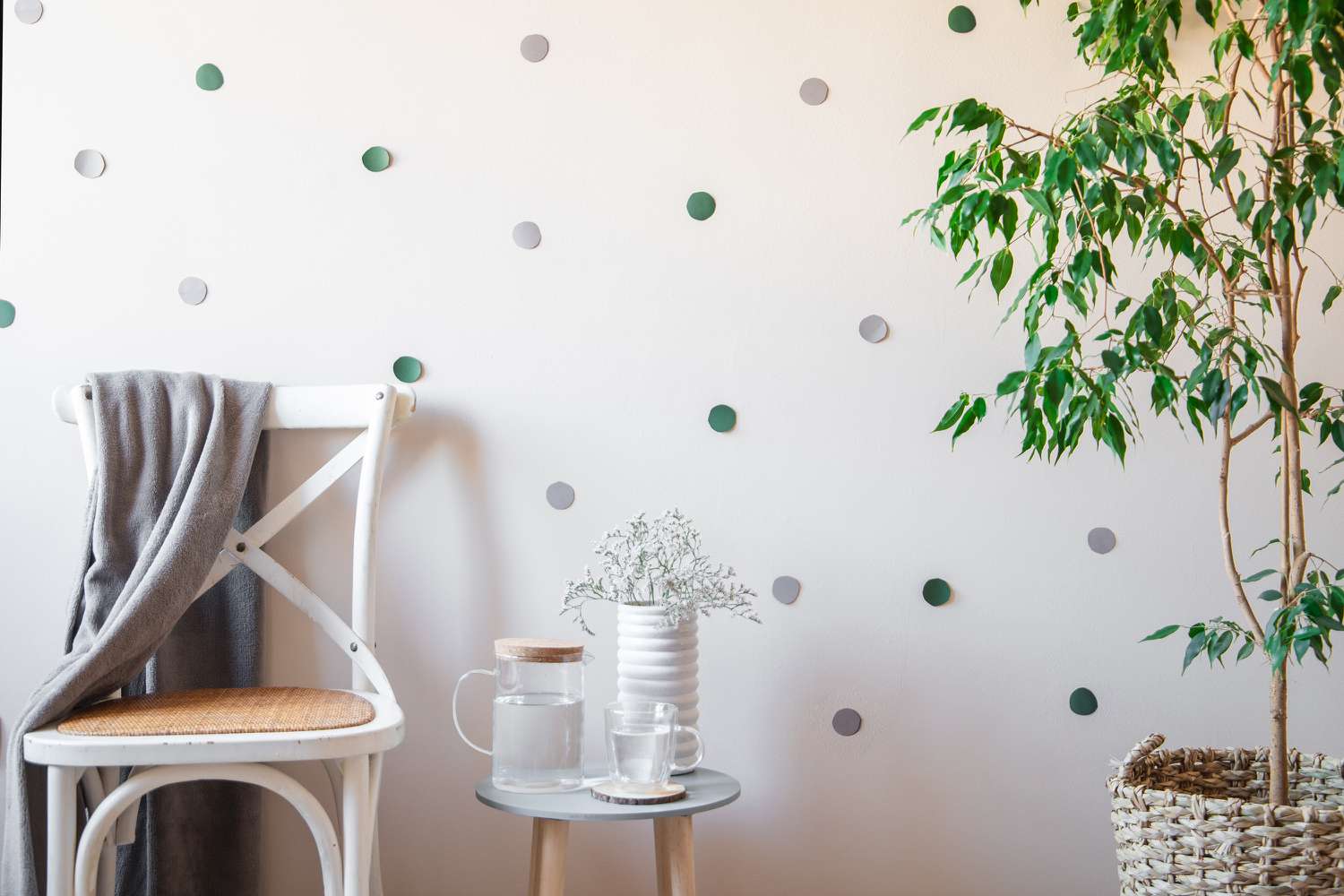 Weiße Wand dekoriert mit grünem und grauem Konfetti zum Abziehen und Aufkleben