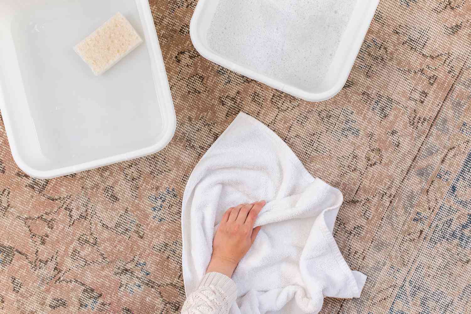 Secar el exceso de humedad de la alfombra de lana con toallas viejas