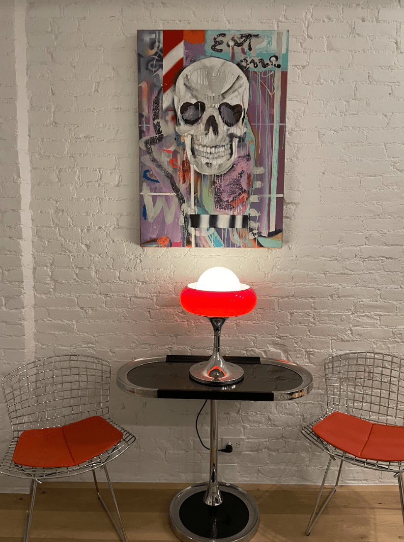 Coin repas avec chaises en métal et peinture de crâne.