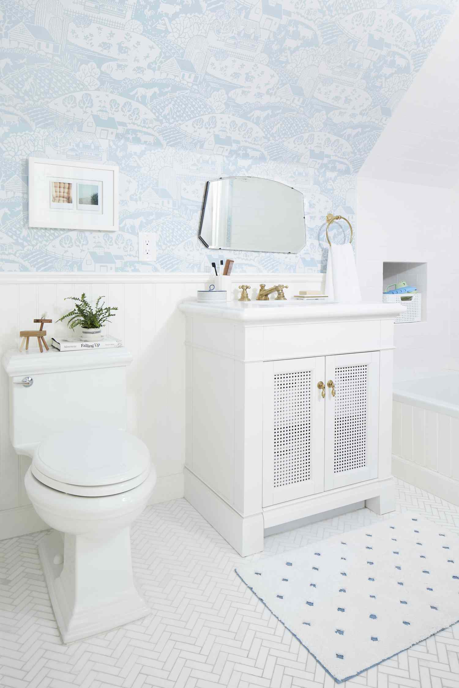 Baño blanco con papel pintado azul claro en paredes inclinadas