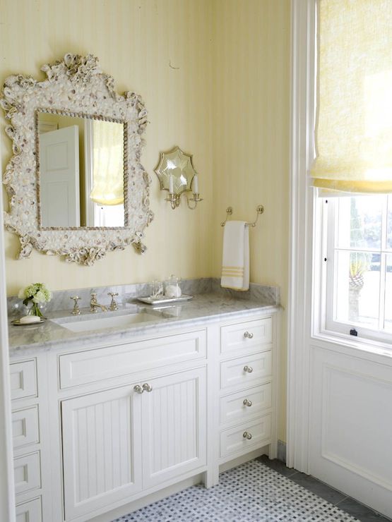 Un tocador de baño de listones con papel pintado amarillo