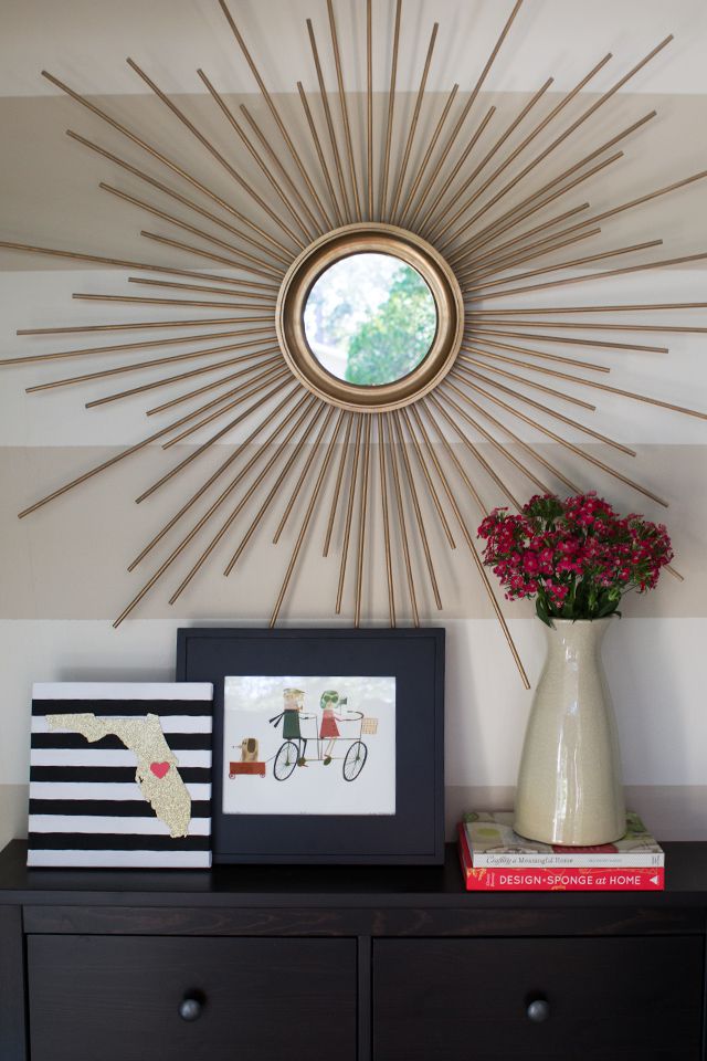 Midcentury modern starburst mirror over a bookshelf