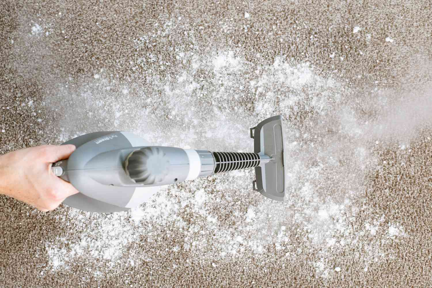 Steamer passing over carpet sprinkled with baking soda and salt