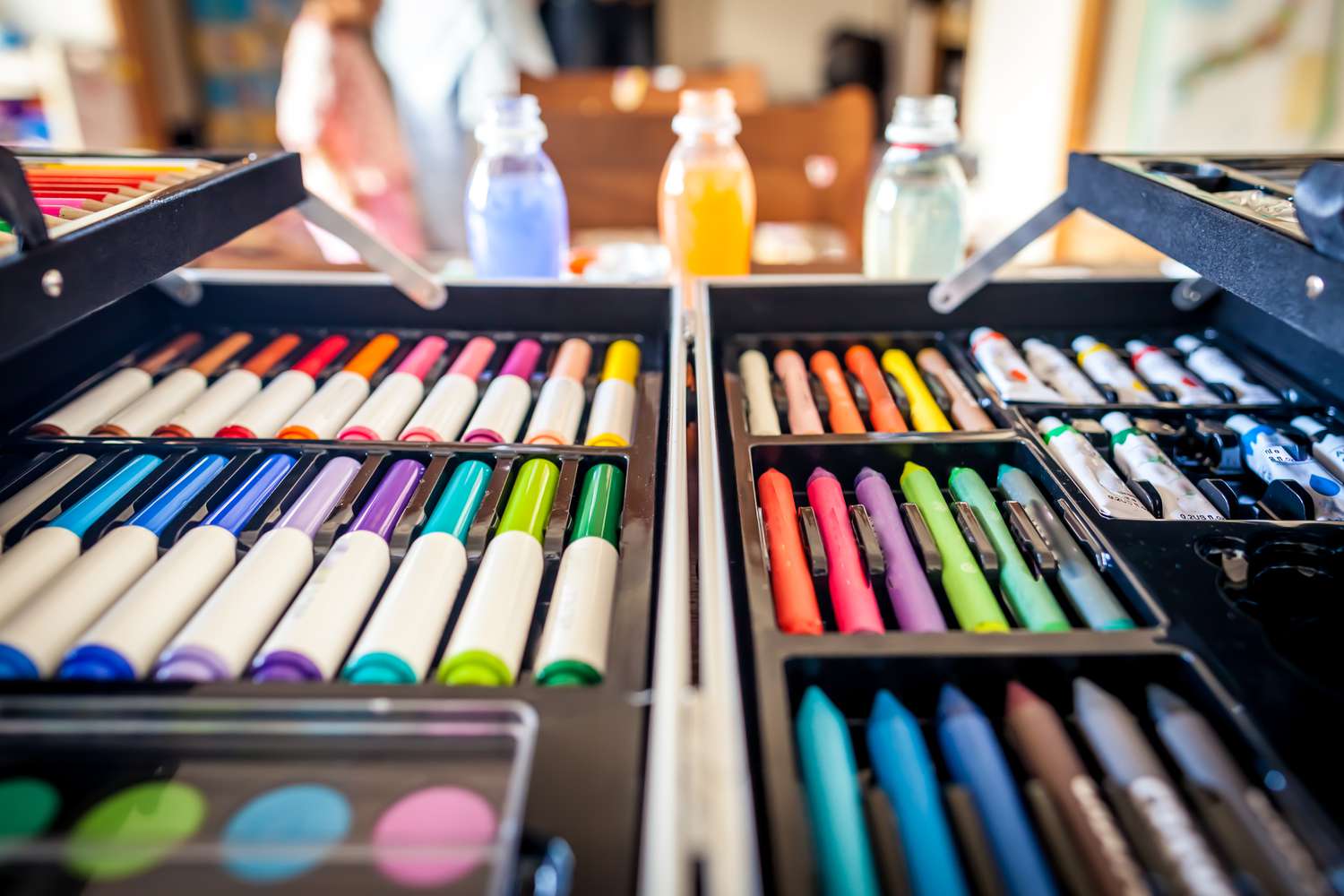 Marker, Pastellstifte und Farben in einem Koffer organisiert