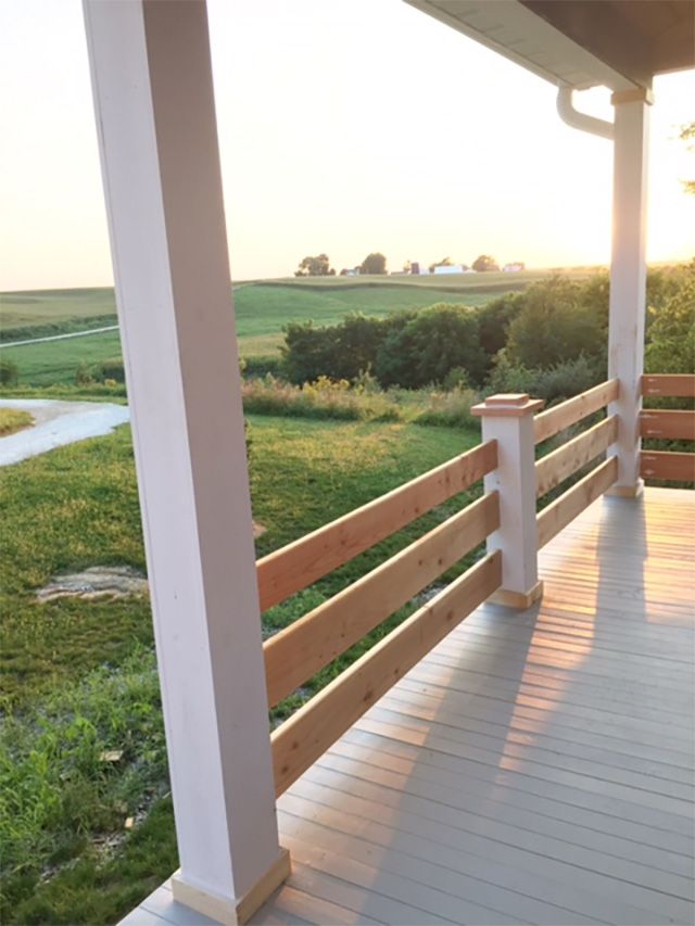 Um corrimão de deck horizontal com vista para um campo