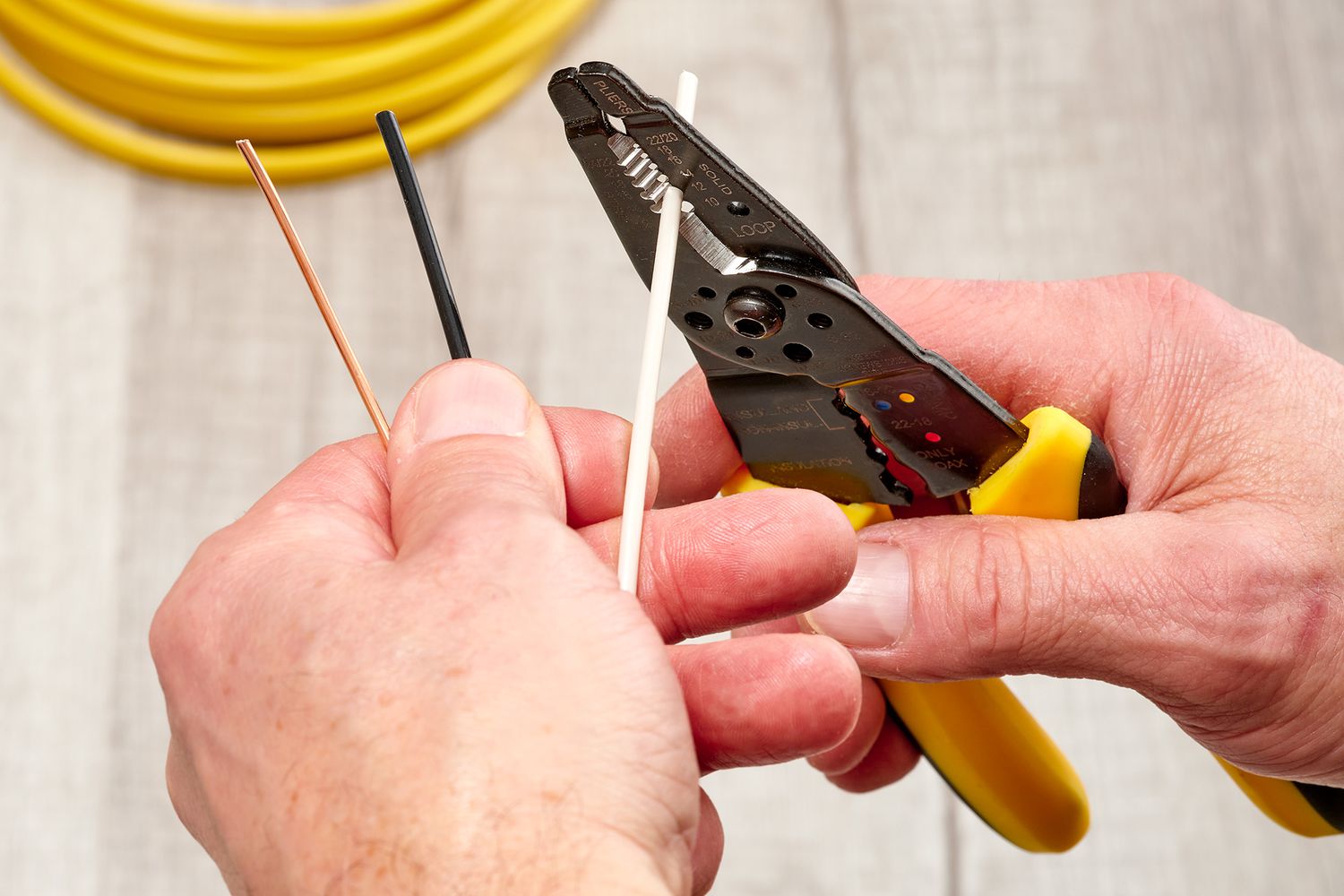 Wire stripper closed on white wire for removal