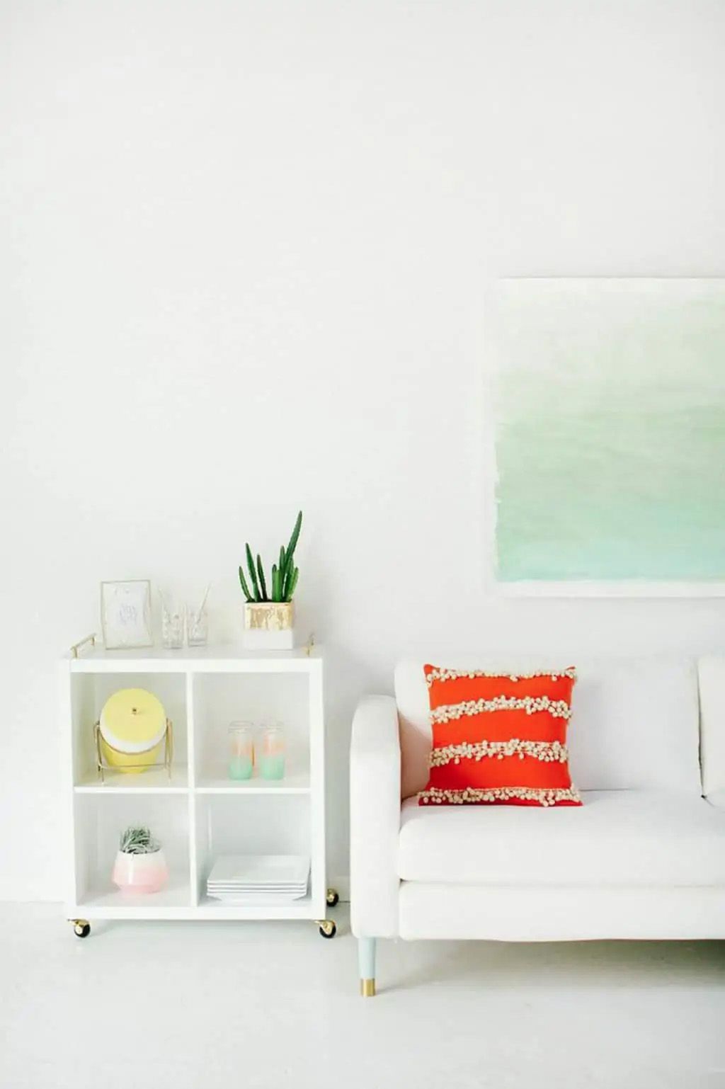 Un cuadro de acuarela verde sobre un sofá blanco