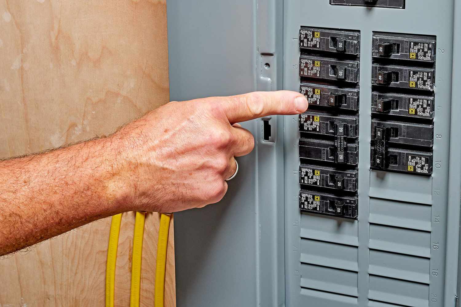 Finger pointing to tripped circuit breaker in service panel