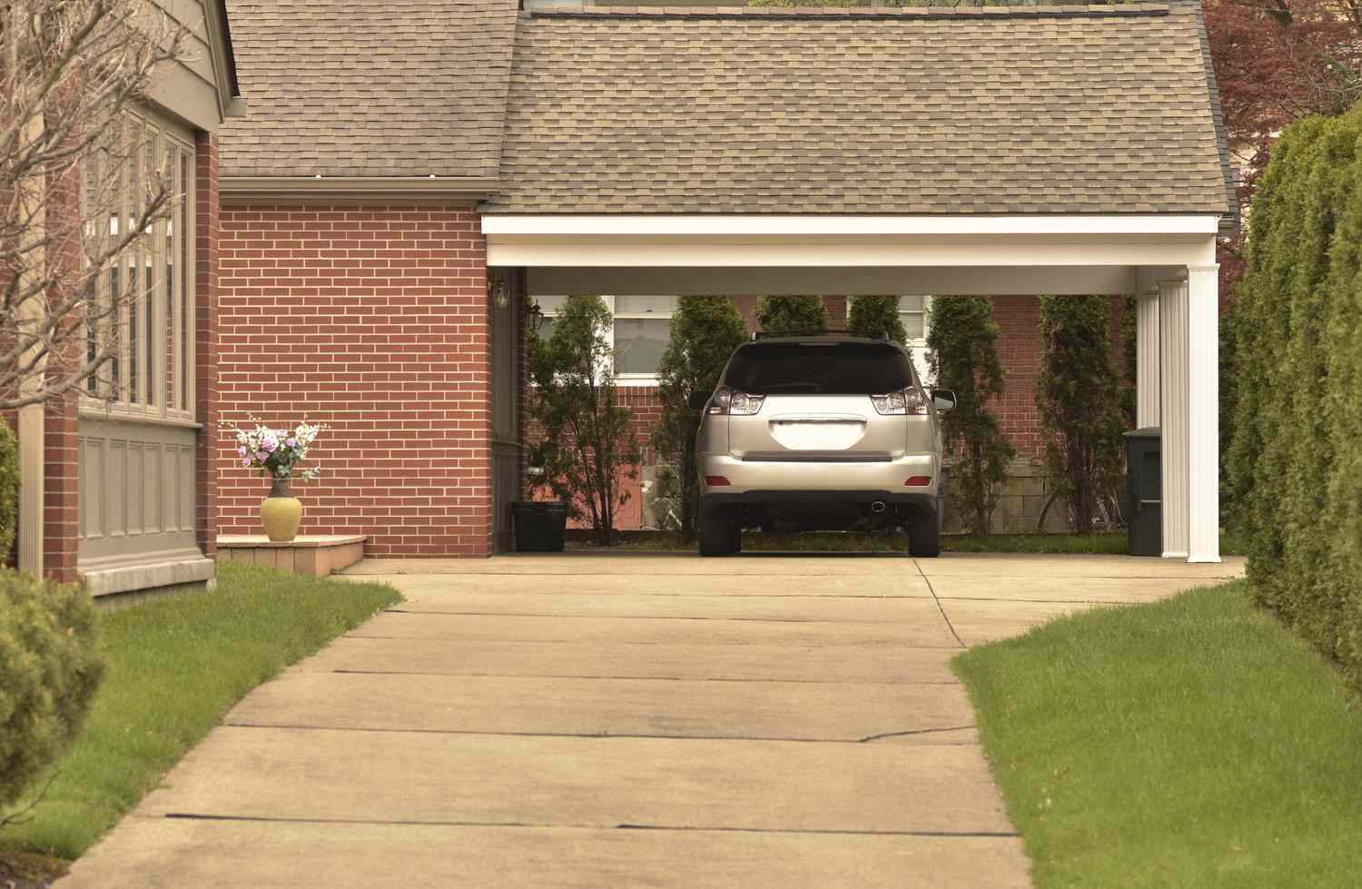 Carport mit geparktem Auto und schön gepflegtem Grundstück