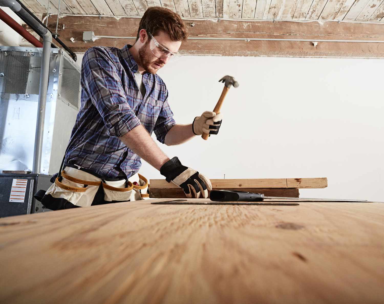 Tischler in der Werkstatt mit Hammer