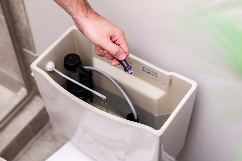 Violetter Lebensmittelfarbstoff, der in den Toilettentank gegeben wird, um ein Sanitärproblem zu finden
