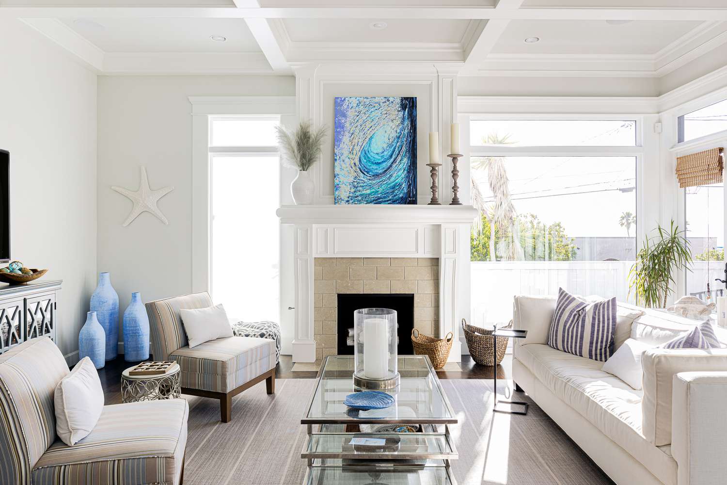 Wohnzimmer im Küstenthema mit einem blauen Gemälde in der Mitte des Raums