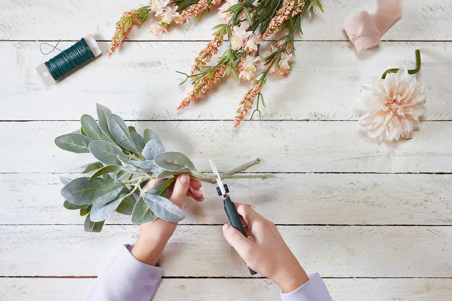 Hands cutting faux flowers